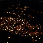 Bedevaartgangers met kaarsen in Lourdes