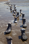 Voetreis, een installatie aan zee van 55 voeten van gietsteen met 55 pakketjes van textiel. Want ieder mens draagt zijn eigen herinneringen, ervaringen en zorgen met zich mee. We groeien door de tijd. © Foto's: Betty van Engelen.