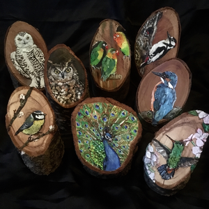 Op hout beschilderde kunstwerkjes, dicht bij de natuur.