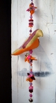 stoffen vogeltje met een kleurige slinger van vilten bloemen en prachtige kralen. erg leuk voor op de kinderkamer. maar ook orgineel als huwelijkskadootje