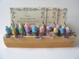 lief versje in een gekleurd kokertje van keramiek, met hartjes en bloemetjes in reliëf en een label met hart.