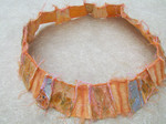 sieraden, kettingen en armbanden, gemaakt van papier en natuurlijke materialen (blaadjes, zaden, bloemen) en stikwerk en beschilderd