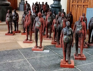 Uit een mal ontstaat een beeld, een tweede, een derde, een vierde, ... een leger verstilde, afwachtende mannen en vrouwen. In totaal werden er 45 mannen en vrouwen uit een mal geboren. In wezen waren ze allemaal gelijk, maar elk beeld kreeg een eigen identiteit door elk beeld handmatig te bewerken met mangaanoxide, een symbool in glazuur aan te brengen of gaten in de klei uit te sparen.
Materiaal: rood bakkende klei bewerkt met mangaan oxide en glazuur, hoog bak
Nog 31 stuks beschikbaar