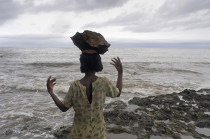 Along the shore at Ambondrona, Nosy Be, families not finding any other means of survival, are making a living by crushing and selling stones. Pieces of stone cut from the seaside rocks are transported to the tiny hamlets of these so-called 