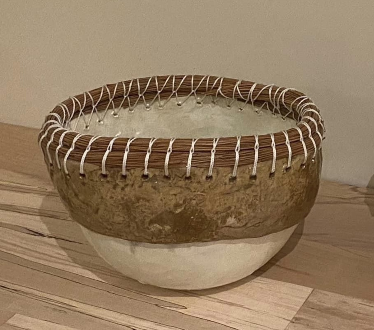 Bijzondere schaal van keramiek met witte parelmoer en goudluster glazuur, met sierrand van omwikkelde dennennaalden met wit draad.