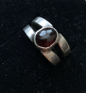 Zilveren gespleten ring ,ingezet met granaat.