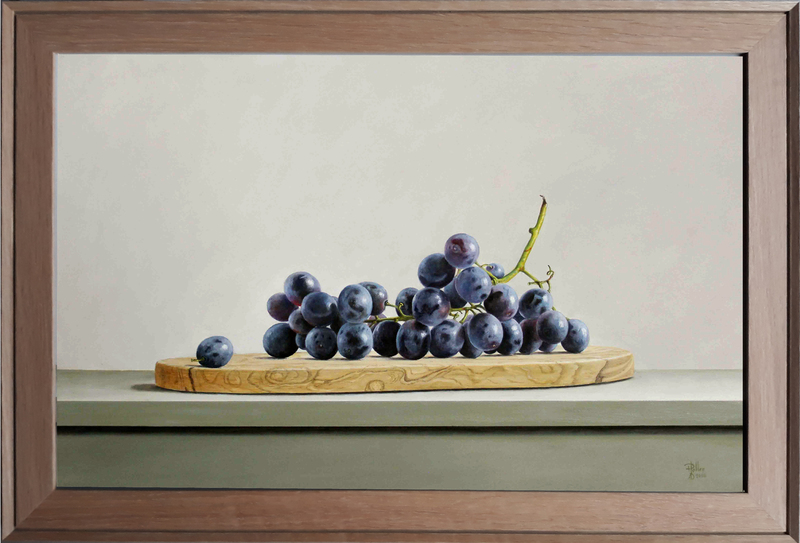 Blauwe druiven op olijfhouten plank