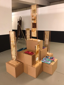 Lange smalle doeken die hangen op een standaard van koperen buizen, waardoor het werk kan rollen.
In 1e instantie waren het doeken gemaakt van de stof van handdoekrollen uit automaten. Dat inspireerde me tot dit ophangsysteem waardoor het rollende effect blijft. Later kwamen er doeken bij van handgeverfde lappen die aan elkaar genaaid werden en geborduurd.