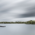 Verstild water met wolkenlucht