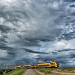 trein onder Nederlandse wolkenlucht