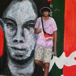 Jongen poseert voor muurschildering in Algiers.