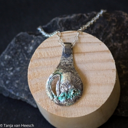 Hanger in druppelvorm van deels gesmolten en geoxydeerd  zilver.