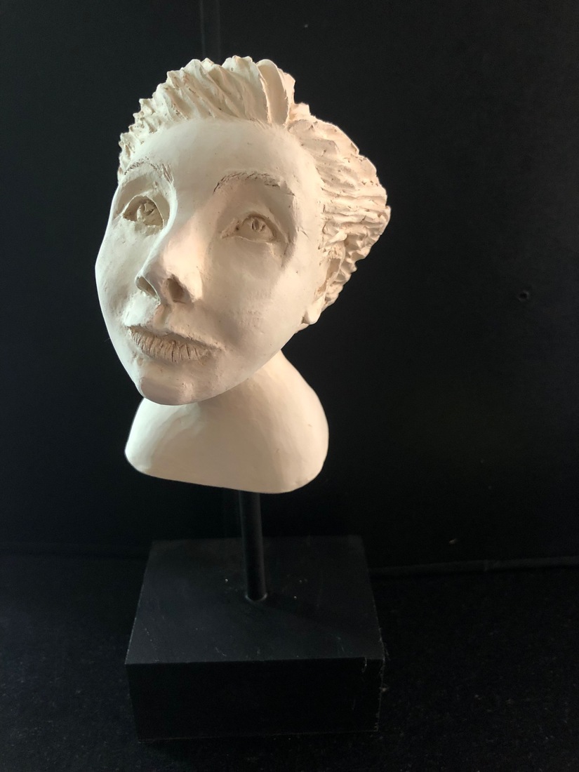 Wit keramiek hoofdje op zwarte sokkel en staafje.