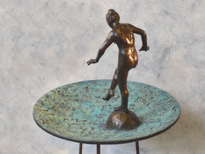 Bronzen beelden in een waterschaal.  