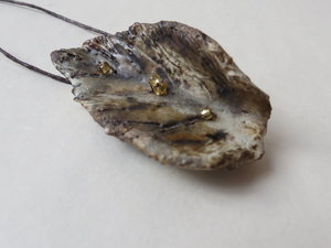 Sieraad bestaand uit een keramisch blad gecombineerd met (parel, edelsteen) kralen.