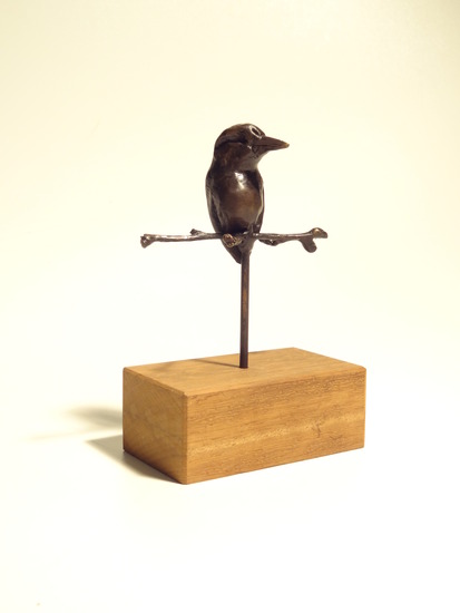 Bronzen vogeltje op takje