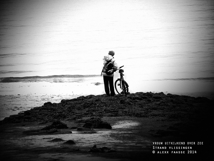 Vrouw tuurt over de zee