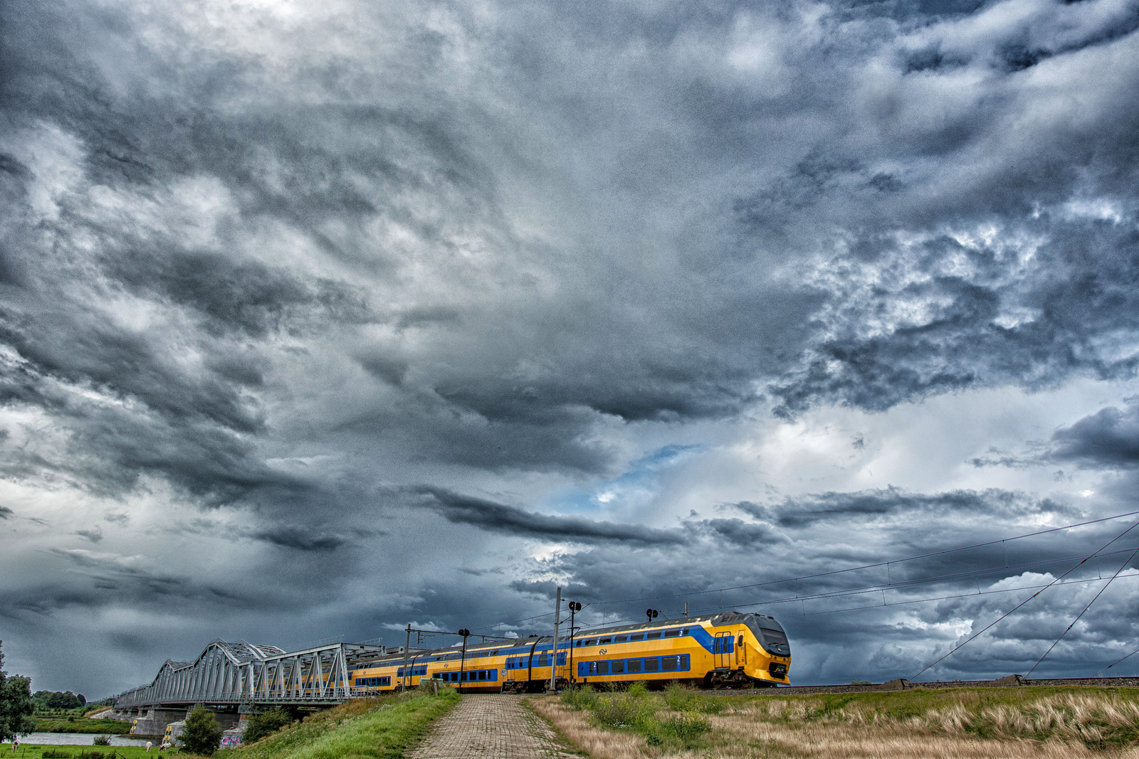 trein onder Nederlandse wolkenlucht