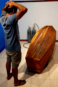 This is a coffin, made for Camilio’s size, with a high-pressure compartment inside so he may take his lifetime Co2 exhaust / footprint with him, into his grave. A high-pressure valve and hose are connected to the coffin and to a high pressure cylinder, so the CO2 from the cylinders – gotten from a filter catch system, which catches Co2 out of our air –, may be injected into the coffin.