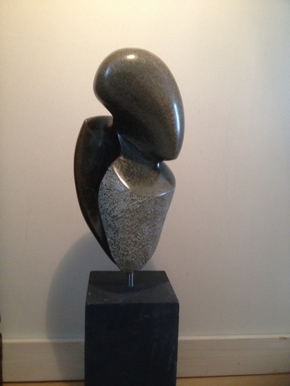 figuur in serpentijn op betonnen sokkel