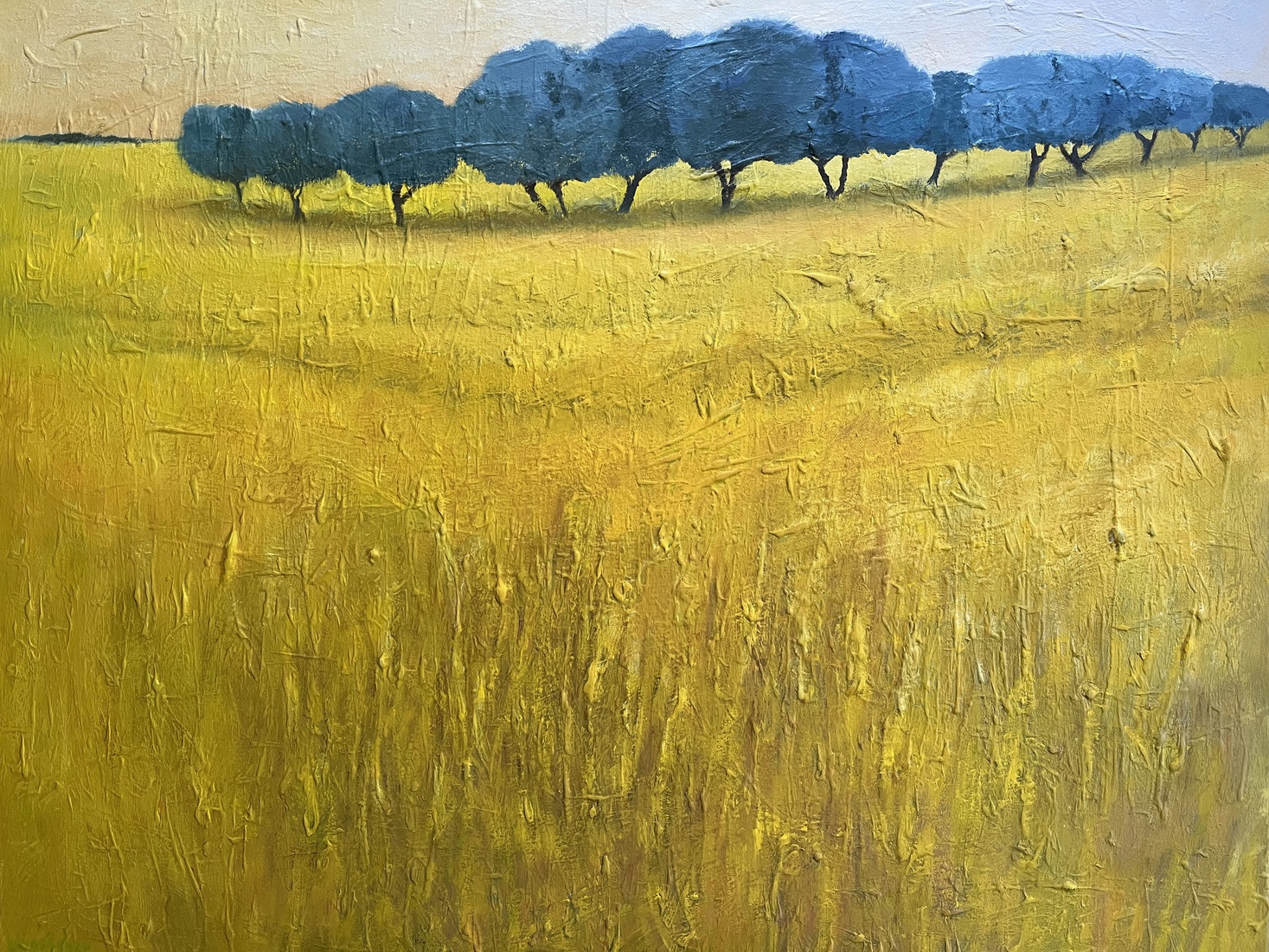 Geel landschap met bomenrij.