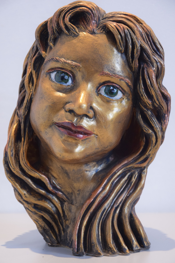 Keramiek borstbeeld van een meisje met de groen blauwe ogen.