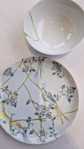 Kintsugi is een eeuwenoude Japanse techniek waarbij gebroken keramiek niet wordt verborgen, maar juist zichtbaar en met goud wordt hersteld. In de 15e eeuw ontstond deze methode toen de Japanse shogun Ashikaga Yoshimasa zijn favoriete theekom liet repareren. In plaats van de barsten te camoufleren, werden ze met lak en goud gevuld – en zo werd het object mooier dan het ooit was.