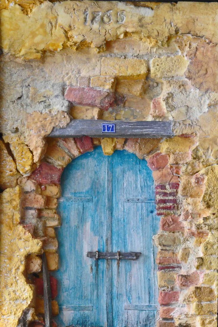Oude stadsmuur met blauwe deur huisnummer 17