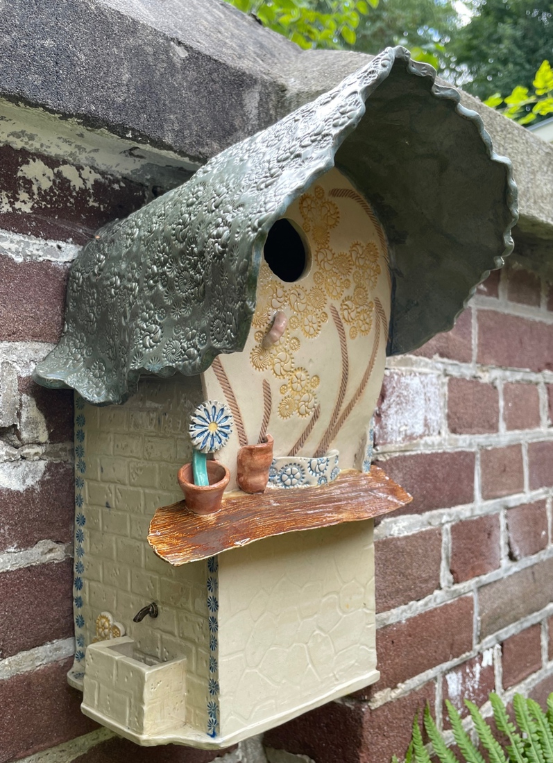 Huis met wasbak en kraan. En prettige vensterbank met bloem. Mezenhuis, steengoed