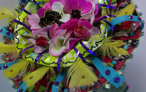 Kunstbloemen van restjes stof, vilt, gevonden vogelveren of andere vonsten uit de natuur.  Versiert met kralen van natuursteen, kleine objecten van keramiek, acrylverf  en/of borduursels.