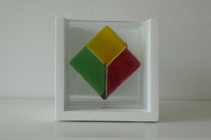 Een driedimensioneel object van geometrische vlakken. De geometrische figuren zijn op vier afzonderlijke glasplaatjes geplakt en gebakken in de oven. Door ze op een decorachtige wijzen achter elkaar te plaatsen ontstaat er een driedimensionaal object. De afmetingen zijn: 17 cm x 17 cm x 16 cm (lengte x hoogte x diepte).