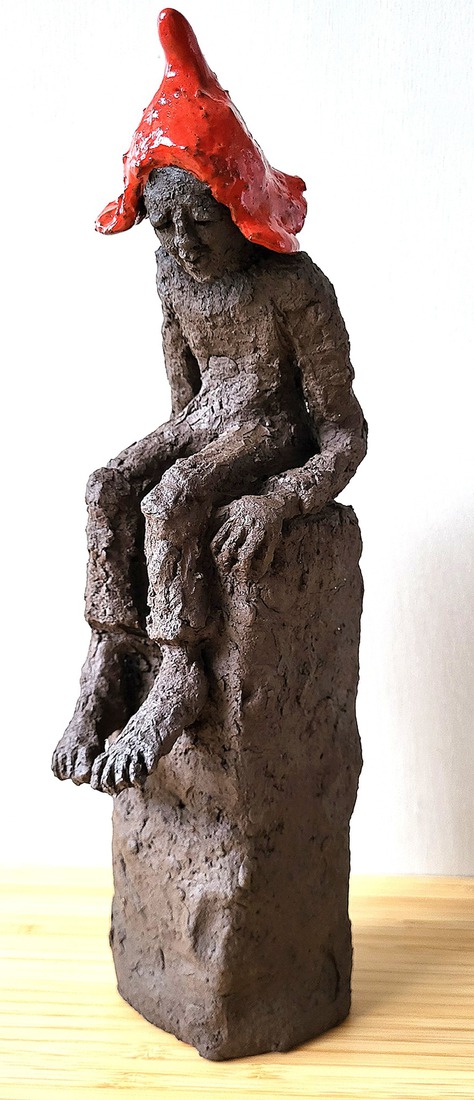 Denkend kijkt hij omlaag.