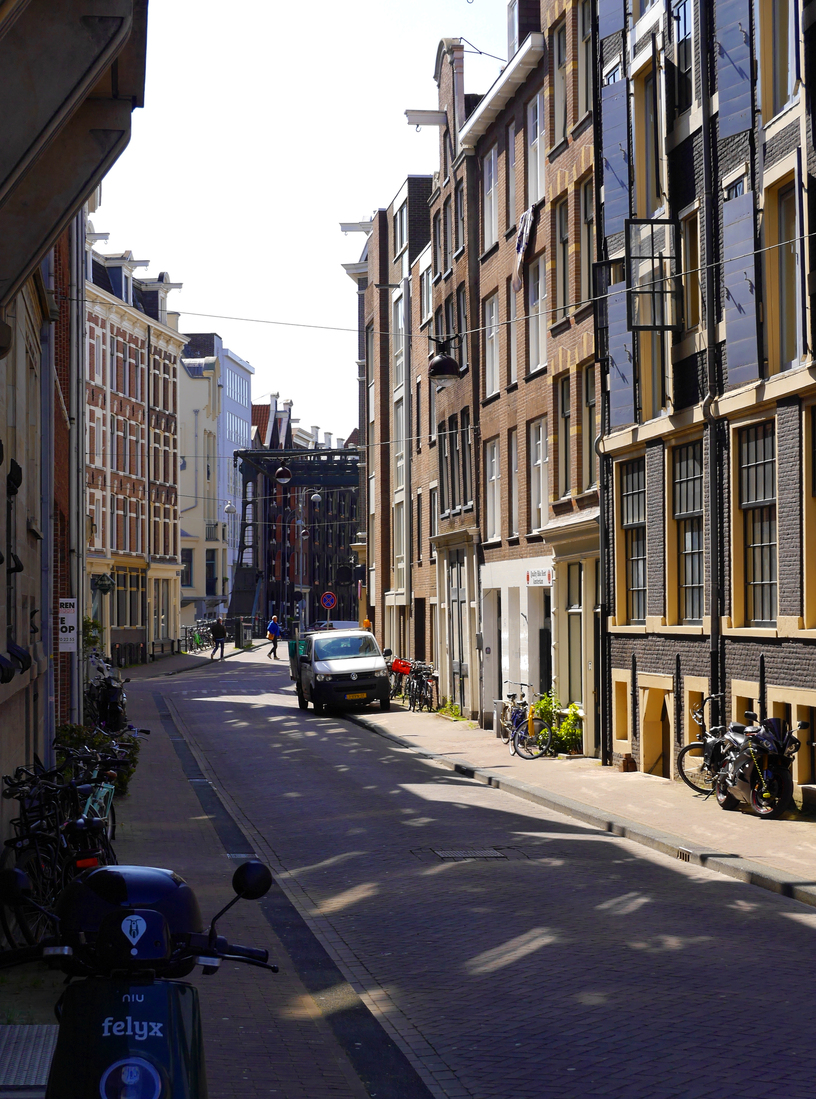 Doorkijk door de Peperstraat met bakstenen huizengevels; Amsterdam centrum in foto voor digitale print