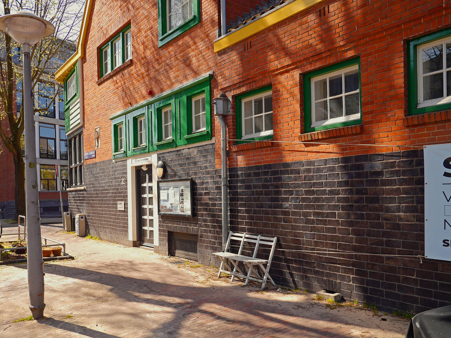Kleurige architectuur van het voormalige badhuis in de zon, op de hoek van de Nieuwe Uilenburgerstraat