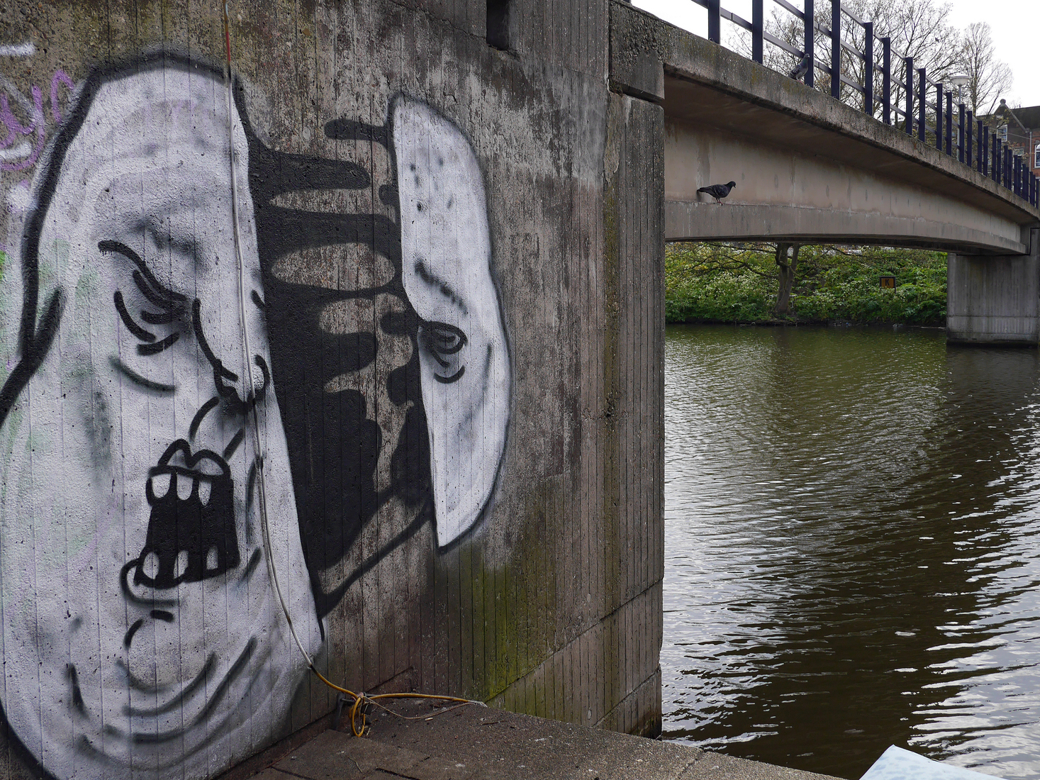 Grote gesprayde graffiti-face op de voet van de loopbrug over de Nieuwe Vaart; foto Amsterdam / Mokum.